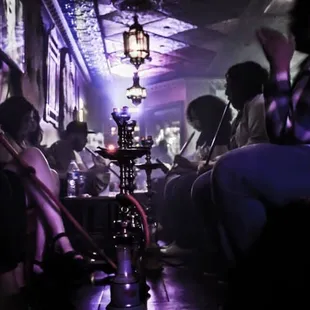 a group of people sitting in a hookah hut