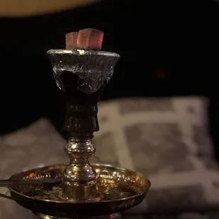 a lit candle on a brass plate