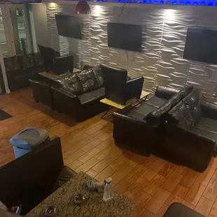 a living room with couches and televisions