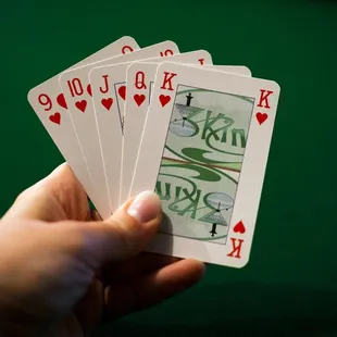 a hand holding four of a kind of playing cards