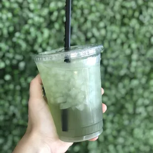 a hand holding a drink with a straw