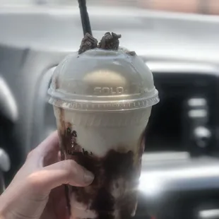 a hand holding a cup of ice cream