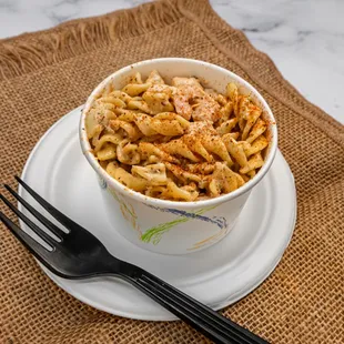 a bowl of pasta on a plate with a fork