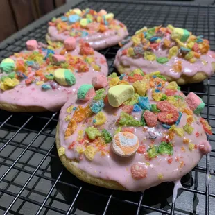 Lucky pebbles cheesecake is lemon cookie dough stuffed original cheesecake; topped strawberry icing, fruity pebbles and lucky charms cereal