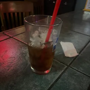 a cold drink with ice and a straw