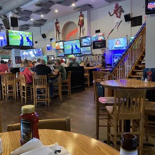 people sitting at tables and watching televisions