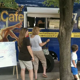 a man and a woman standing in front of a bus