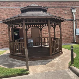 a gazebo in front of a brick building