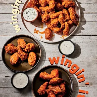 a plate of chicken wings and a bowl of ranch dressing