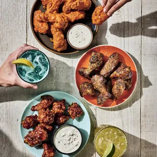 a bowl of chicken wings and a bowl of dips