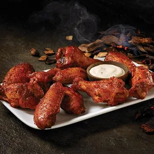 a plate of chicken wings with dipping sauce