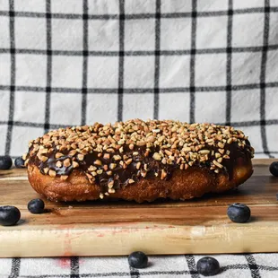 a donut on a cutting board with blueberries