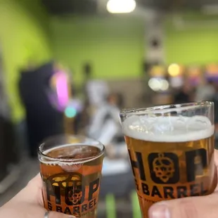 two people holding glasses of beer