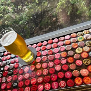 a beer and a tray of beer caps