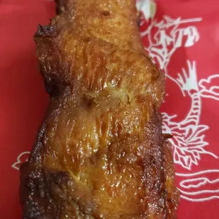 a chicken skewer on a red napkin