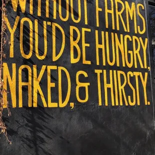 a sign on the side of a building that says without farms you&apos;d be hungry naked and thirsty