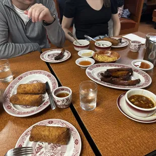 two people sitting at a table with plates of food