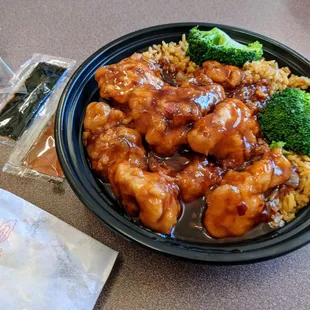 a bowl of food with rice and broccoli