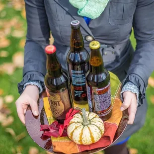 a woman holding a tray of beer bottles