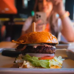 a woman taking a picture of her burger