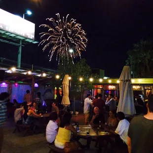 a crowd of people sitting at tables outside at night