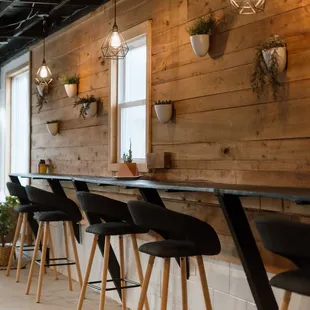 a row of bar stools in front of a wood paneled wall