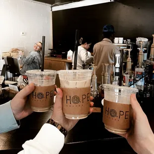 two people holding cups of coffee
