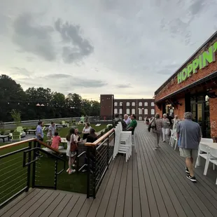 people sitting at tables on a deck