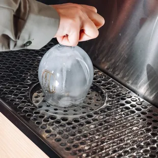 a person filling a glass with ice