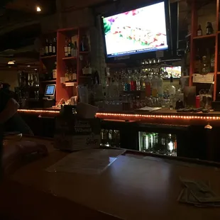 a man sitting at a bar watching tv