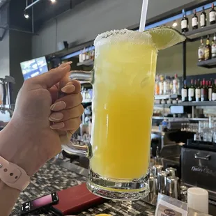 a person holding a glass of orange juice