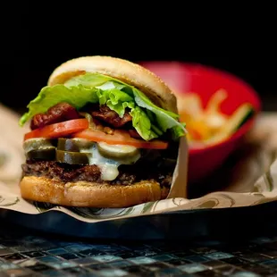 a hamburger with lettuce, tomato, and cheese