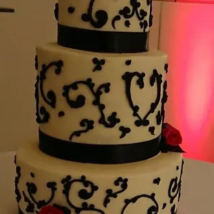 a three tiered cake with red roses