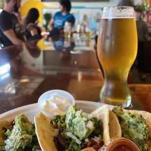 a plate of tacos and a beer