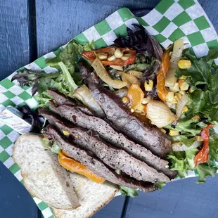 a steak sandwich and salad