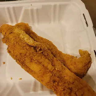 fried fish in a styrofoam container
