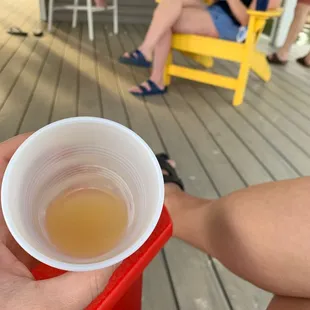 a woman sitting on a porch with a cup of tea