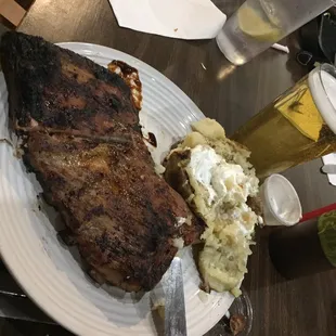 a plate of steak, mashed potatoes, and beer