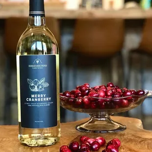 cranberries in a bowl and a bottle of wine