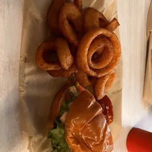 a burger with onion rings and ketchup