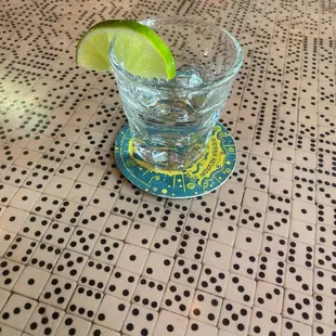 a shot of a glass of water with a lime slice in it