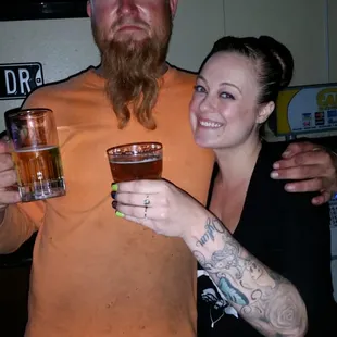 a man and a woman holding glasses of beer