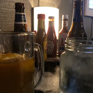 Beer, water, all the condiments imaginable on the table.
