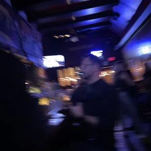 a blurry image of a man at a bar