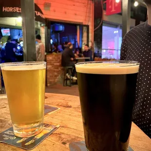 a man sitting at a table with two beers