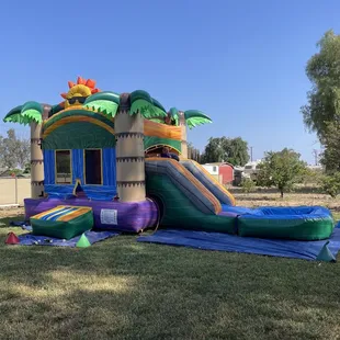 Tropical bounce house with water slide attachment.