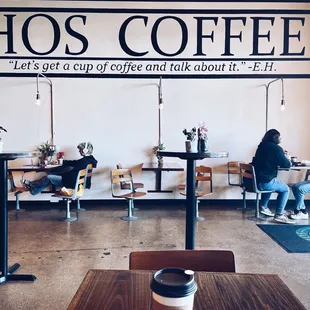 two people sitting at tables in a coffee shop