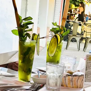 a table with two glasses of mojita