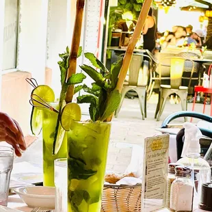 a table with two glasses of mojita