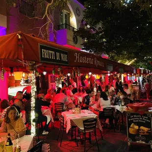 a crowded street with tables and chairs